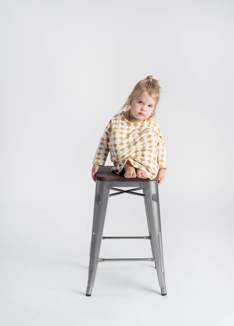 young girl sitting on a stool