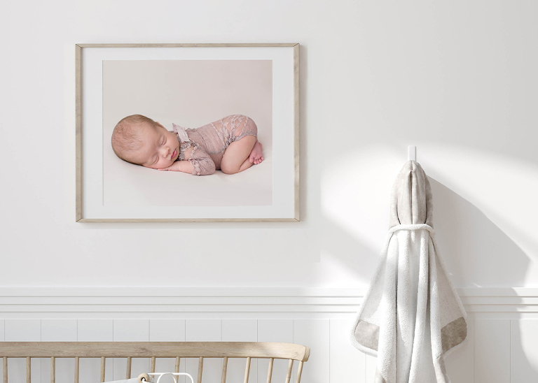 newborn picture in a frame on the wall of a baby's room