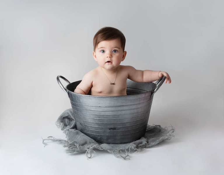 baby girl in metal bucket