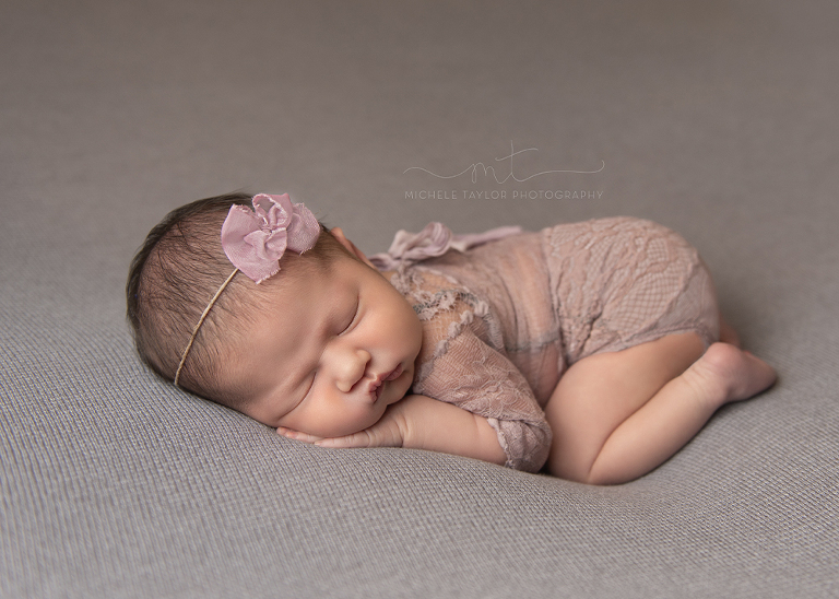 Newborn baby in outfit with bow