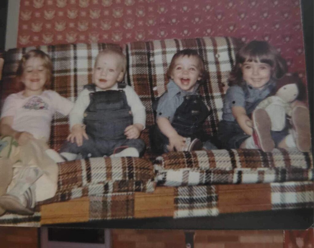 4 children sitting on a plaid couch from the 1970's