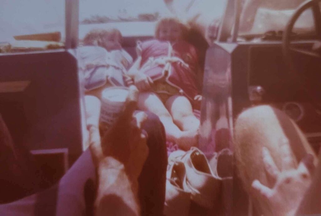 2 young girls in lifevests on a boat from the late 70's