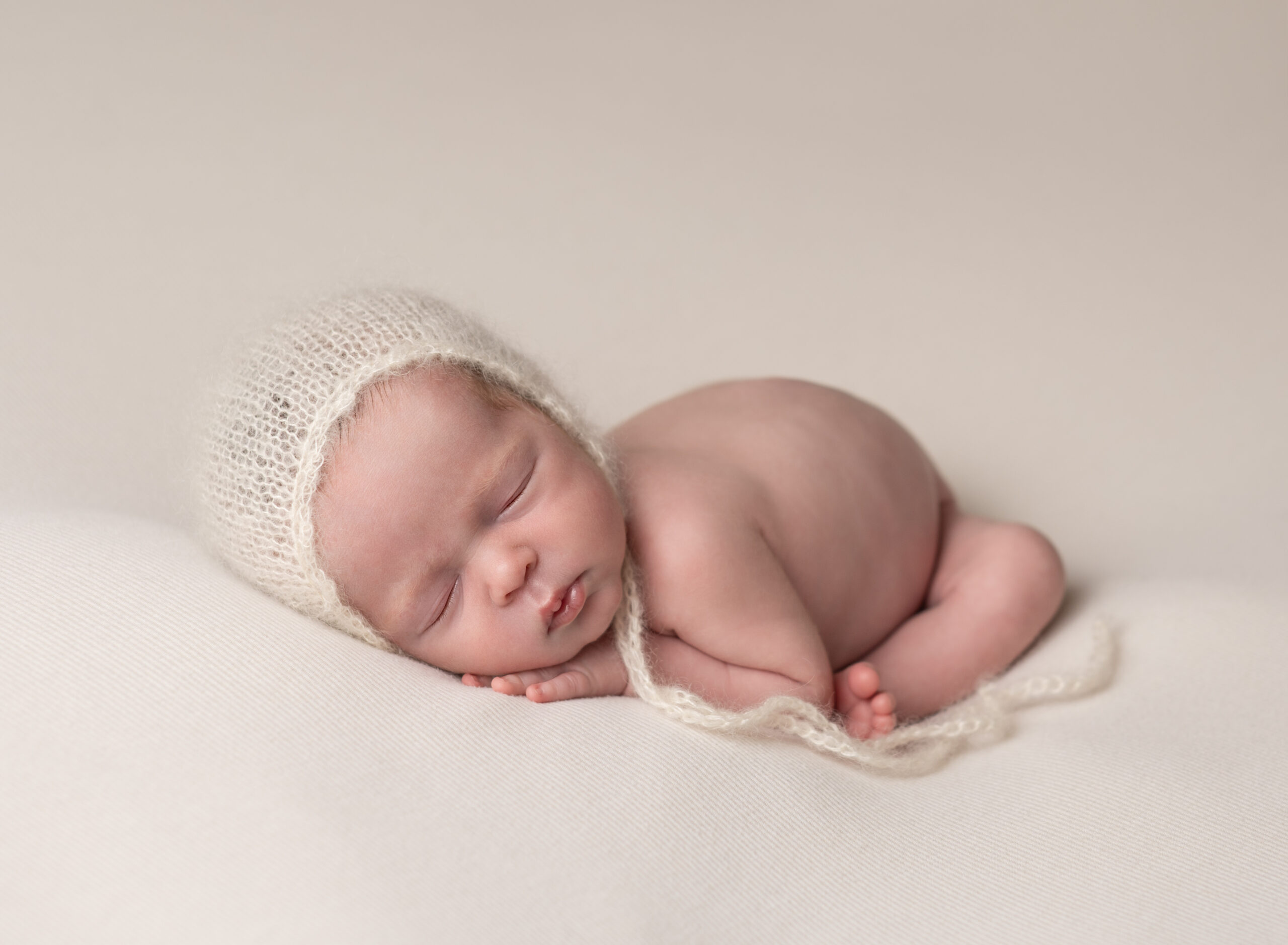 newbrn baby in cream knit hat