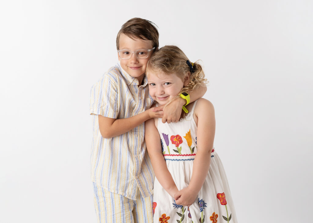 brother hugging his sister posing for their school pictures