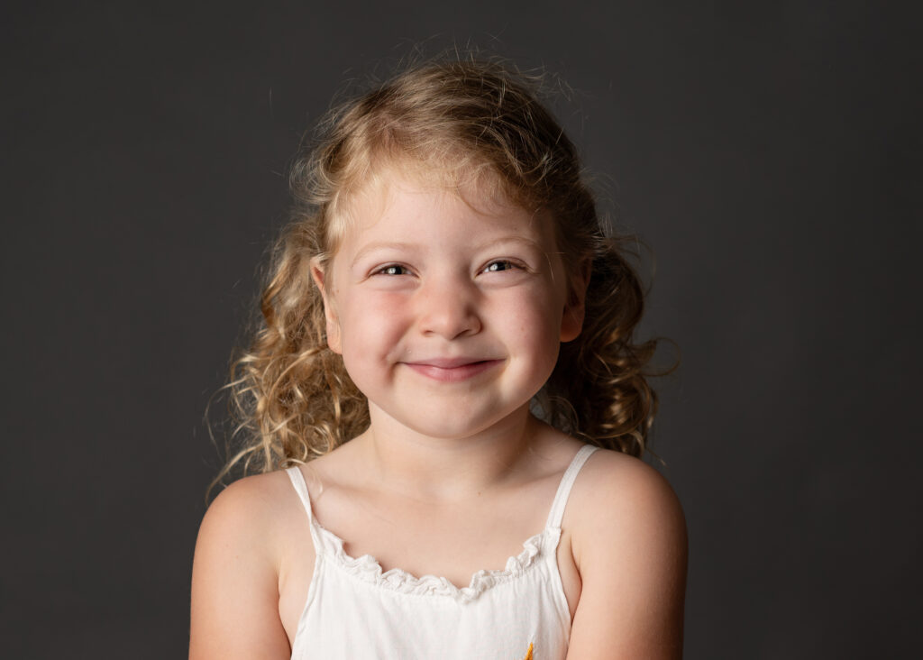 super smiley young girl with curly hair in pigtails