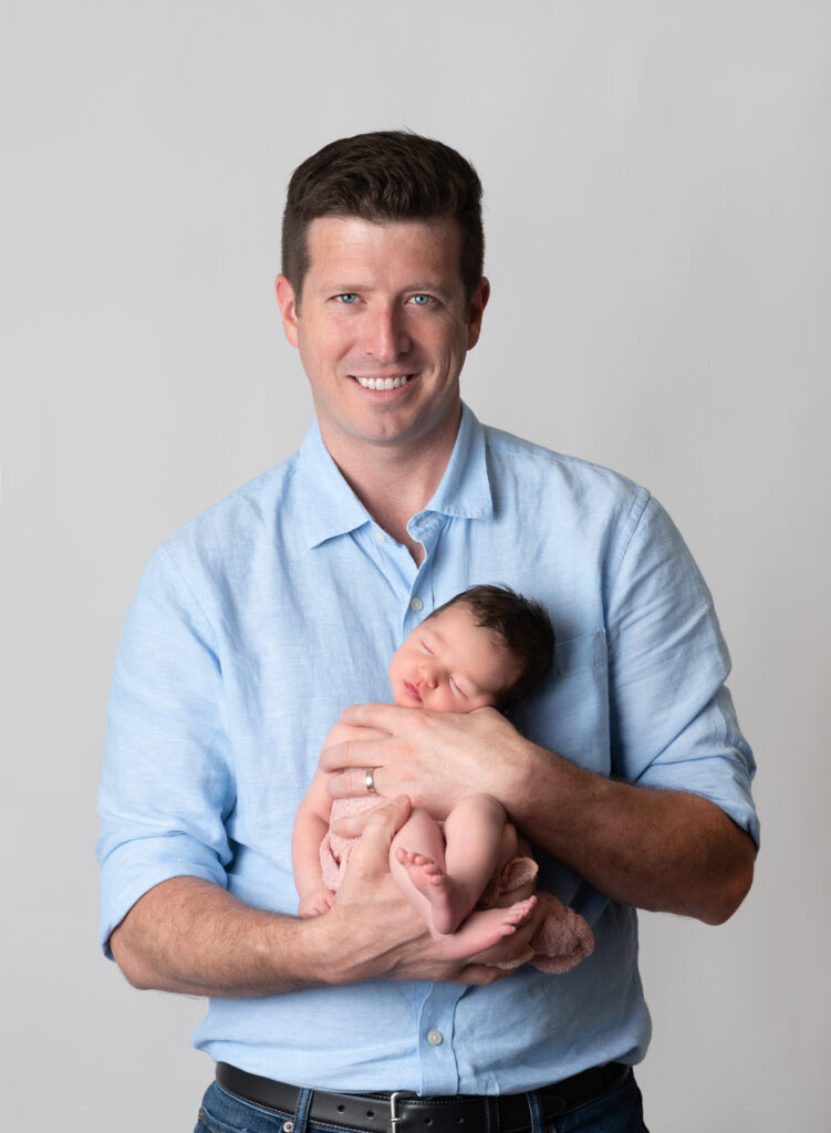 new dad posing with his baby girl for newborn famly photos