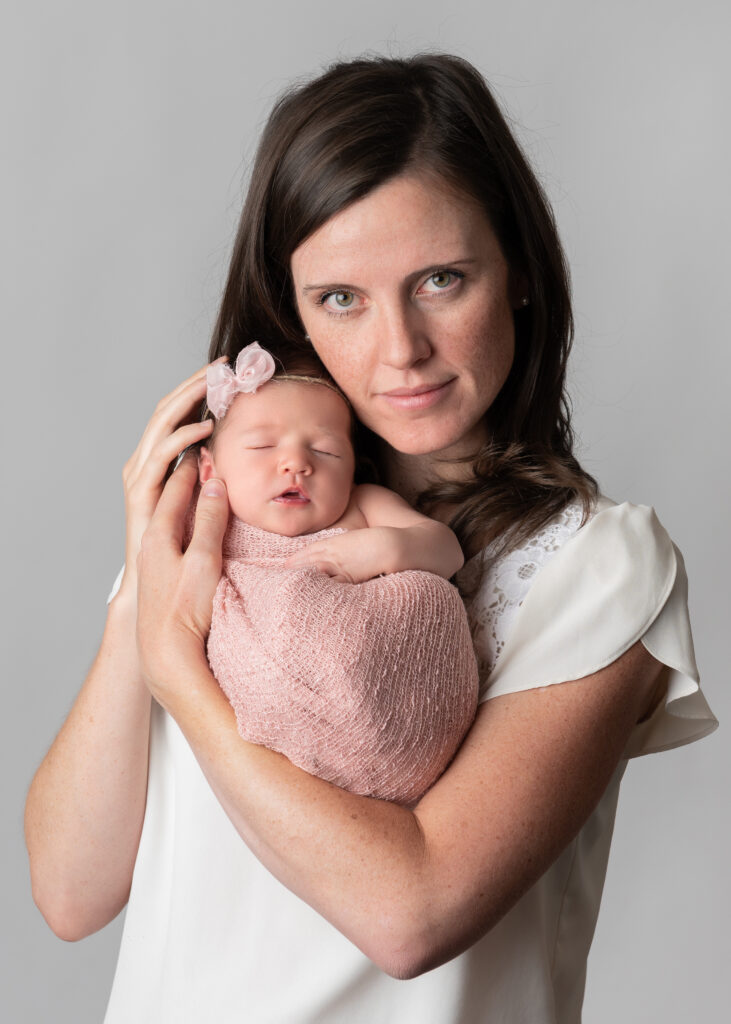 New mom cradling her newborn daughter for newborn family photos